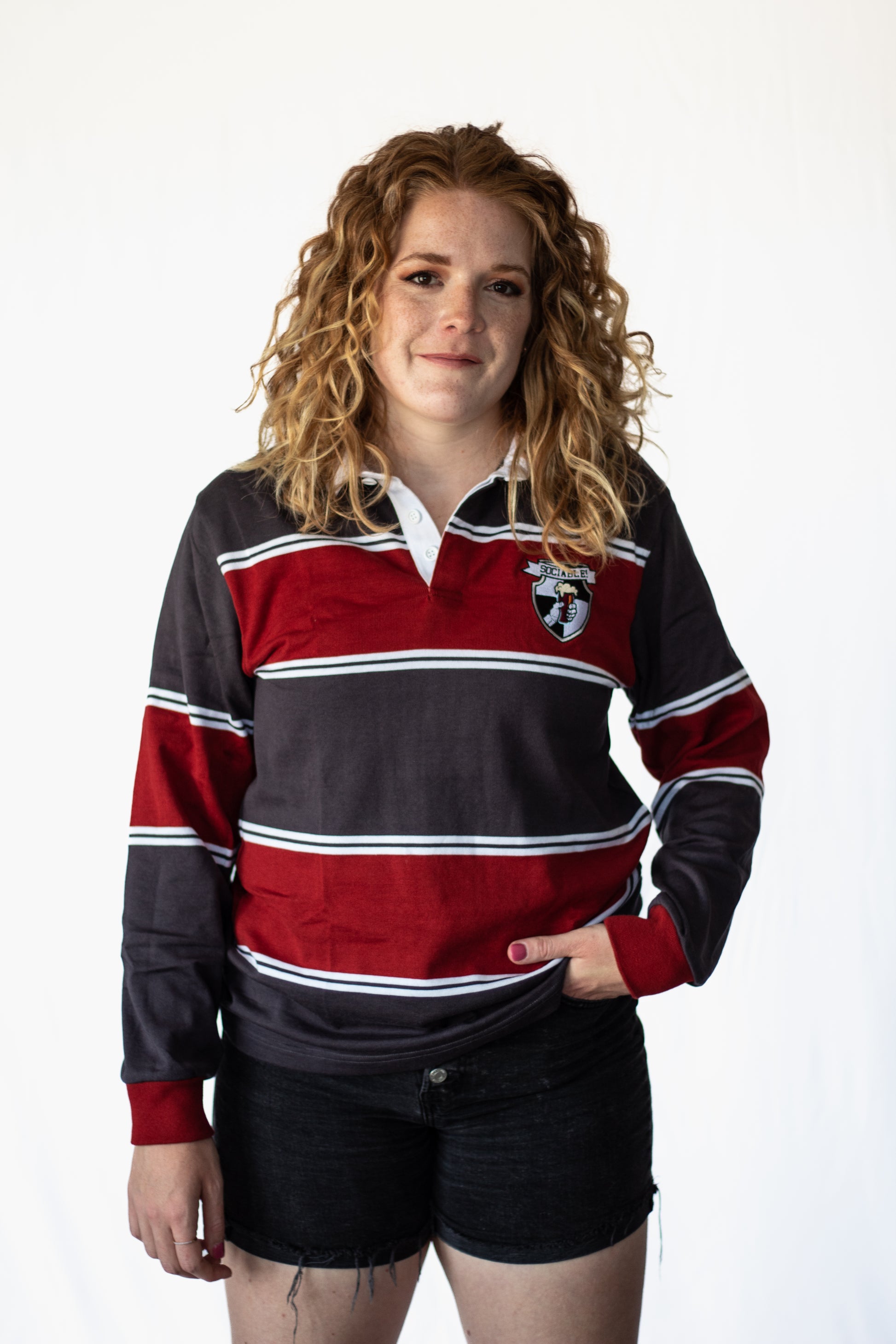A woman wearing a red and grey sociable rugby shirt