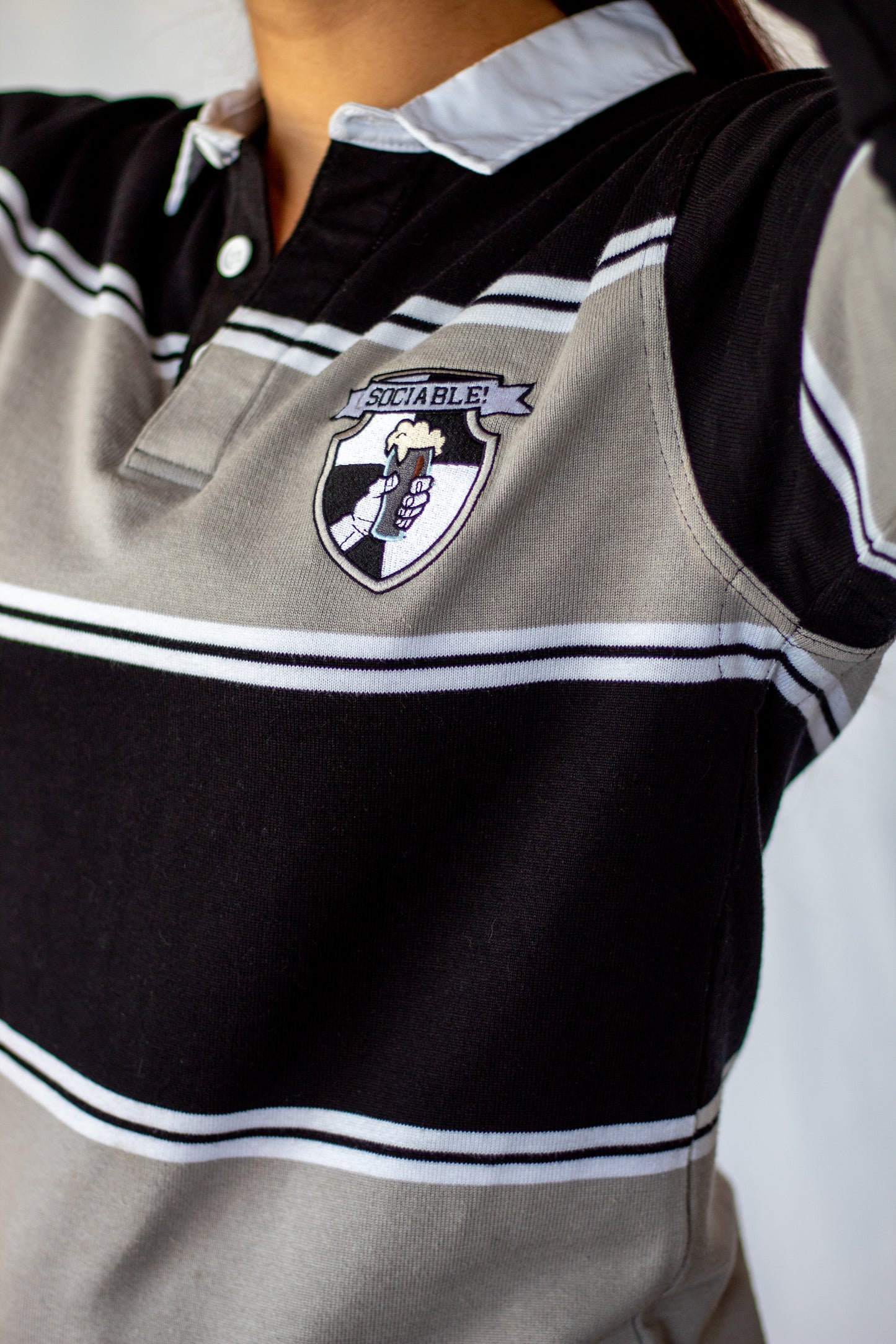 A black and grey rugby shirt with sociable beer crest